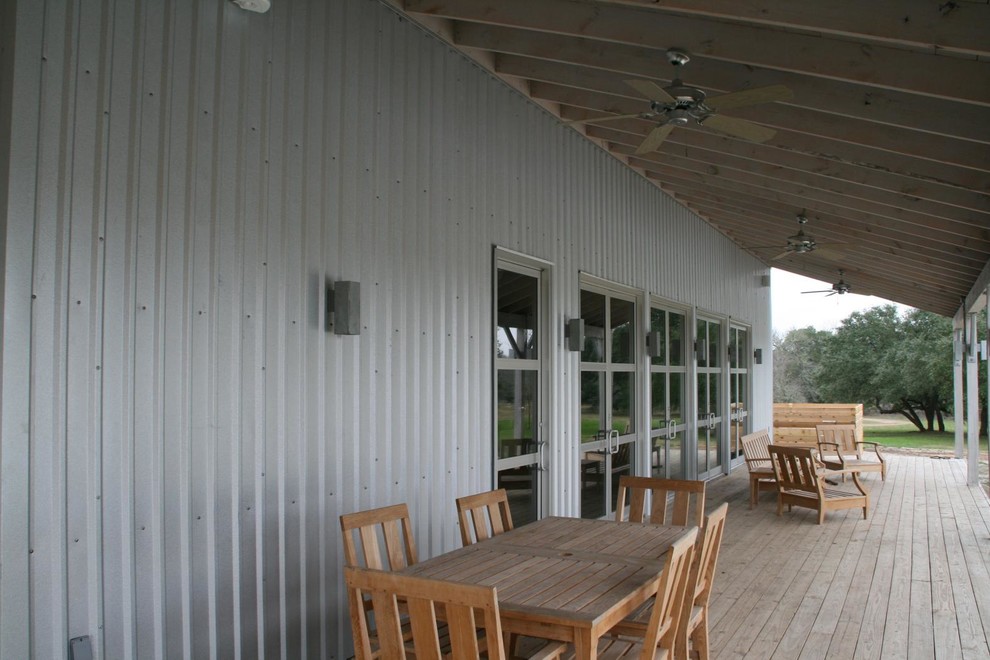 This is an example of a huge cottage back porch design in Austin with decking and a roof extension.