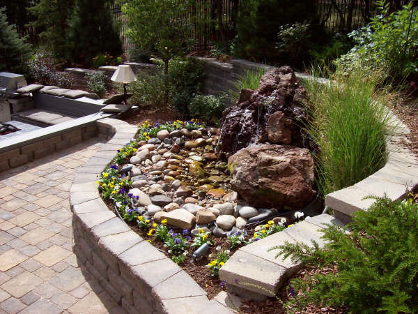 Ejemplo de jardín asiático de tamaño medio en patio trasero con fuente y adoquines de piedra natural