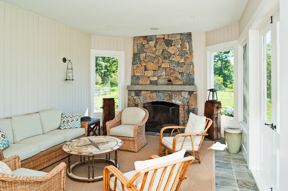 Cette photo montre un grand porche d'entrée de maison arrière chic avec une moustiquaire, des pavés en pierre naturelle et une extension de toiture.