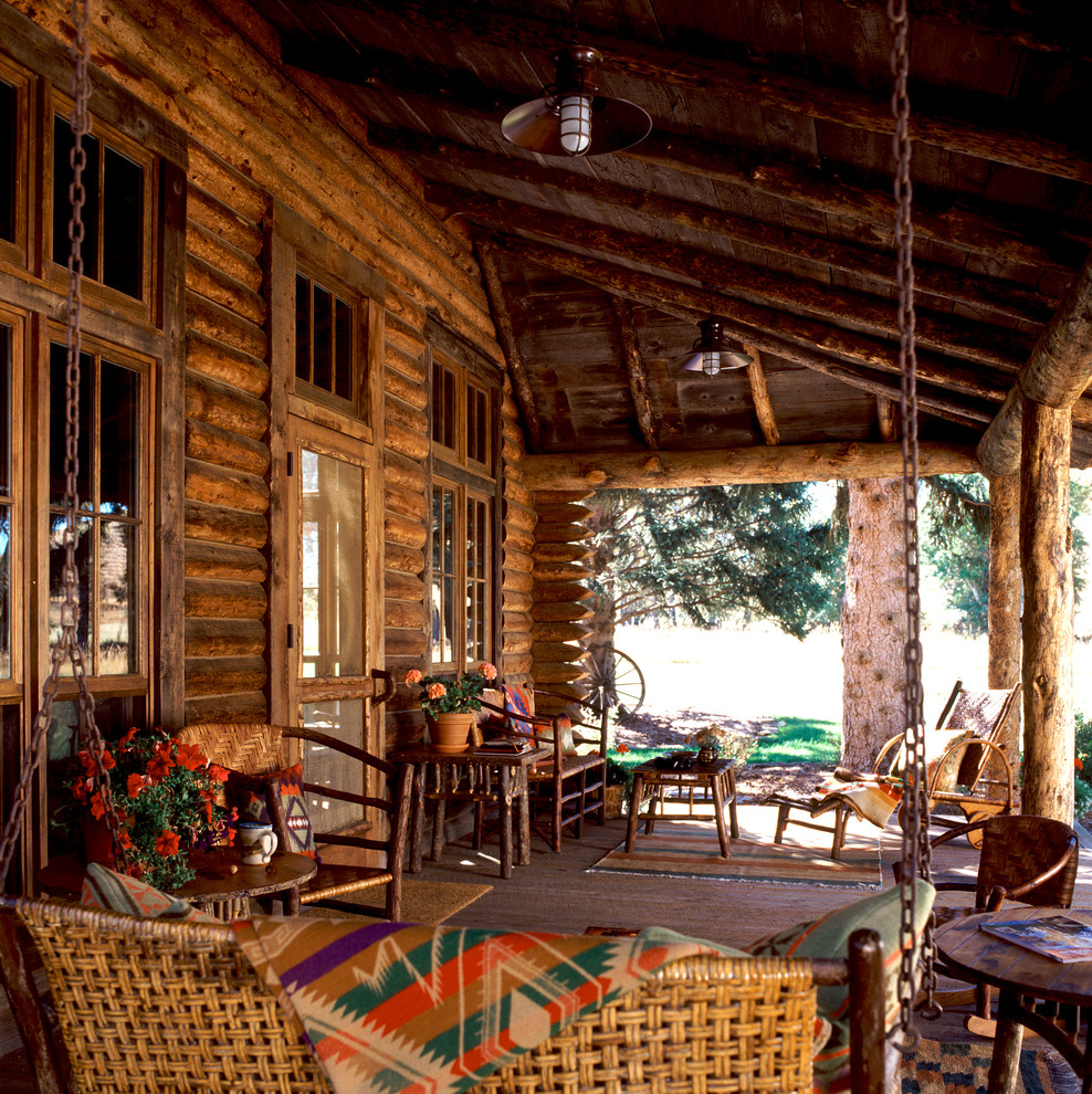 Exemple d'un porche d'entrée de maison montagne de taille moyenne avec une terrasse en bois et une extension de toiture.