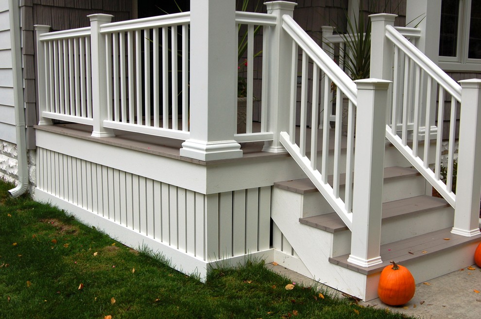 This is an example of a small traditional front porch design in Milwaukee with decking and a roof extension.