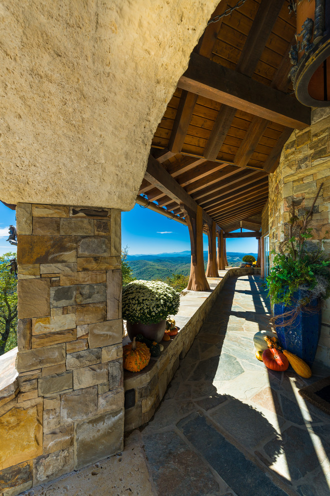 Imagen de terraza rústica extra grande en patio delantero y anexo de casas con adoquines de piedra natural