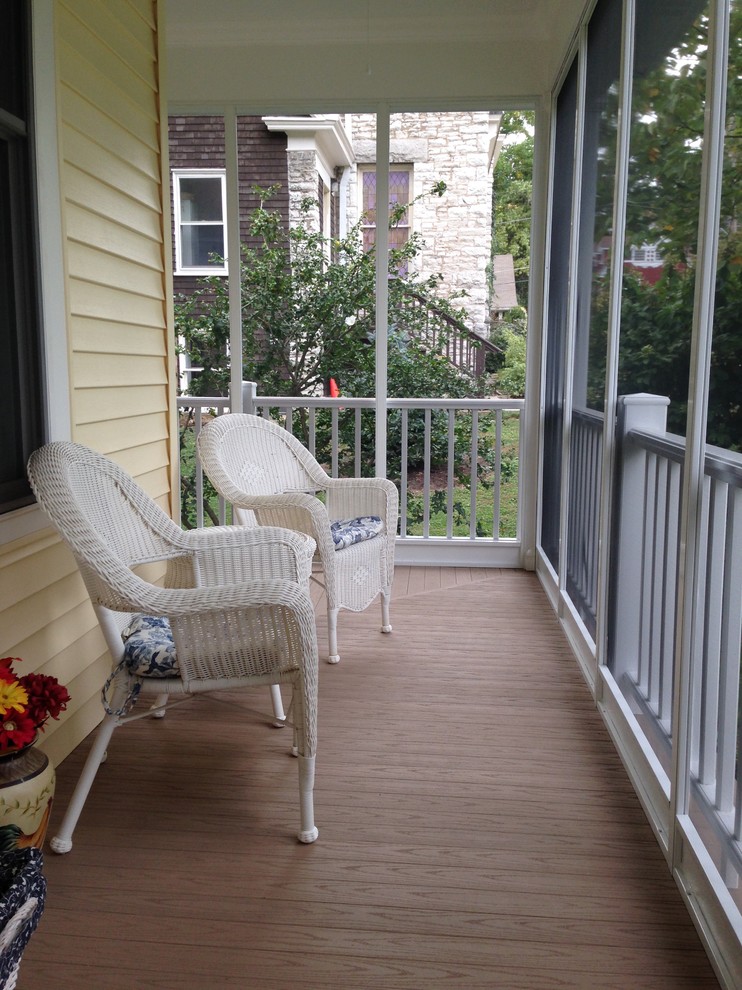Exempel på en mellanstor klassisk innätad veranda framför huset, med trädäck och takförlängning