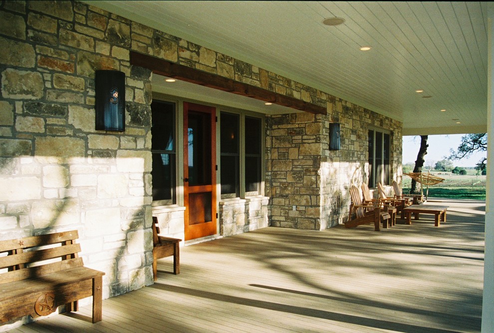 Exemple d'un grand porche d'entrée de maison avant nature avec une terrasse en bois et une extension de toiture.