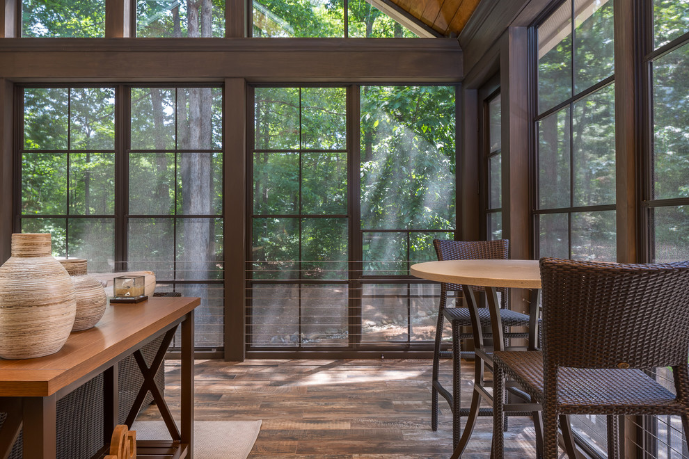 Inspiration pour un grand porche d'entrée de maison arrière chalet avec un foyer extérieur, des pavés en béton et une extension de toiture.