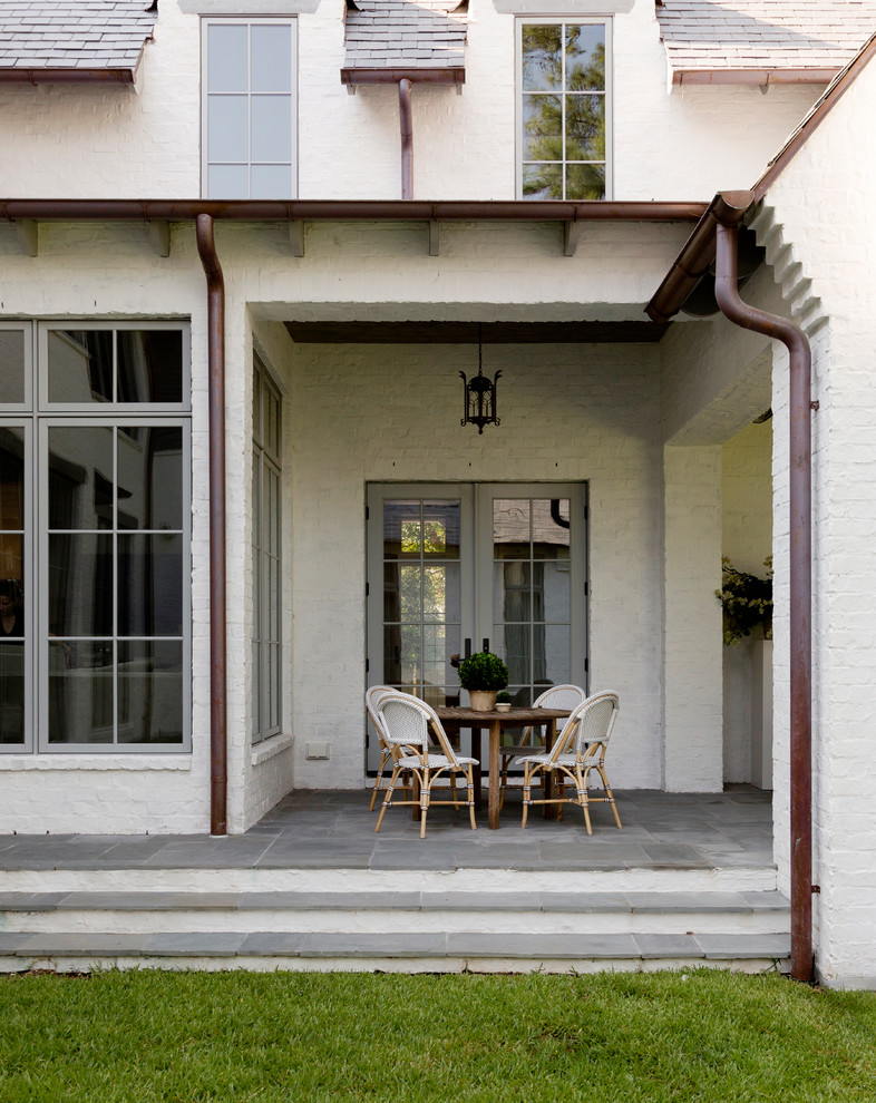 Cette image montre un porche d'entrée de maison arrière rustique avec des pavés en béton et une extension de toiture.