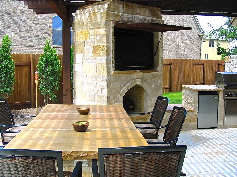 Example of a large mountain style backyard stone patio design in Austin with a fire pit and a pergola