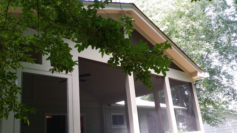Idéer för mellanstora vintage innätade verandor på baksidan av huset, med naturstensplattor och takförlängning