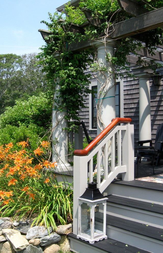 Foto på en mellanstor rustik veranda på baksidan av huset, med trädäck och en pergola