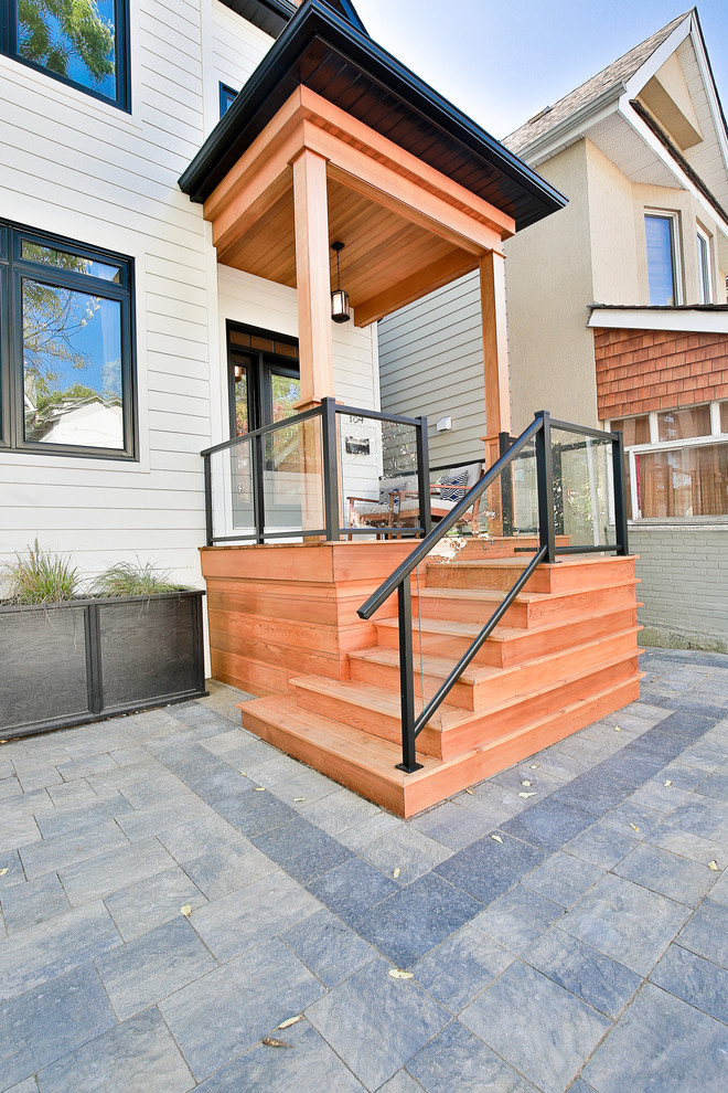 Imagen de terraza moderna pequeña en patio delantero con entablado y toldo