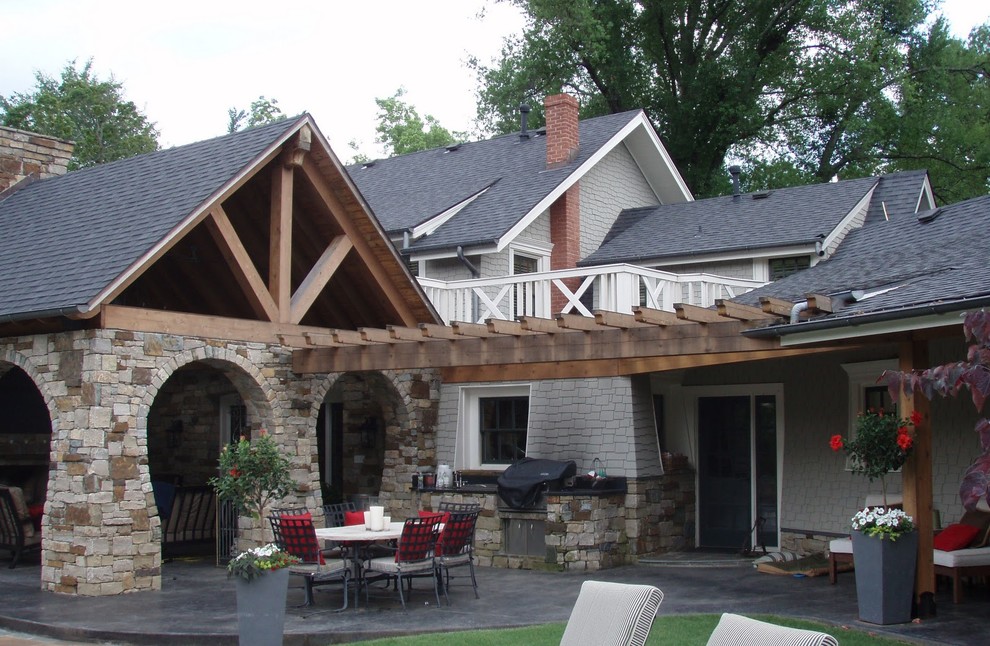 This is an example of a large traditional back veranda in Other with an outdoor kitchen, concrete paving and a roof extension.