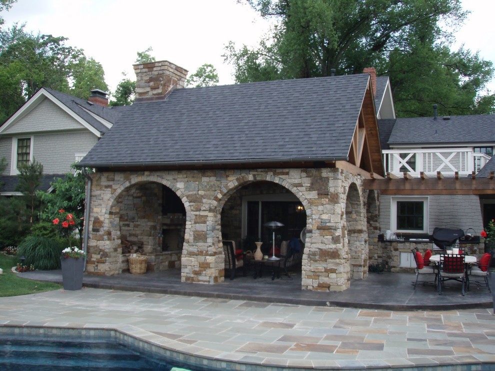 Modelo de terraza de estilo americano grande en patio trasero y anexo de casas con cocina exterior y adoquines de hormigón