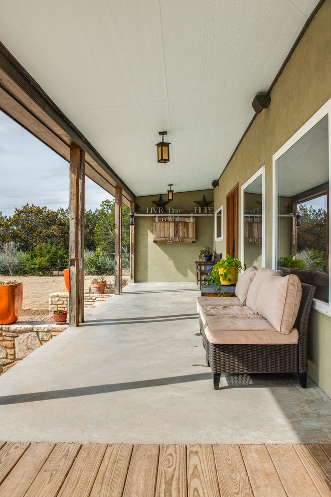Inspiration för en mellanstor amerikansk veranda framför huset, med betongplatta och takförlängning