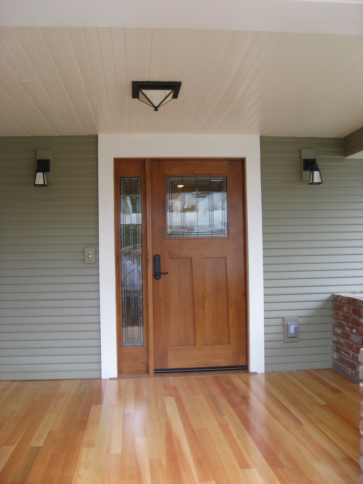 Immagine di un portico stile americano davanti casa con un tetto a sbalzo e pedane