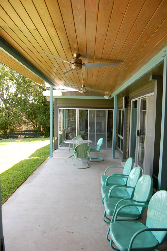 This is an example of a midcentury veranda in Austin with concrete slabs and a roof extension.