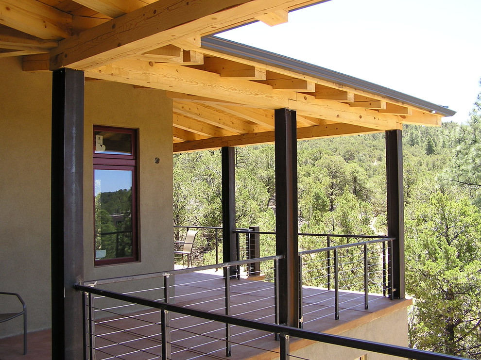 Bild på en mellanstor funkis veranda på baksidan av huset, med betongplatta och takförlängning