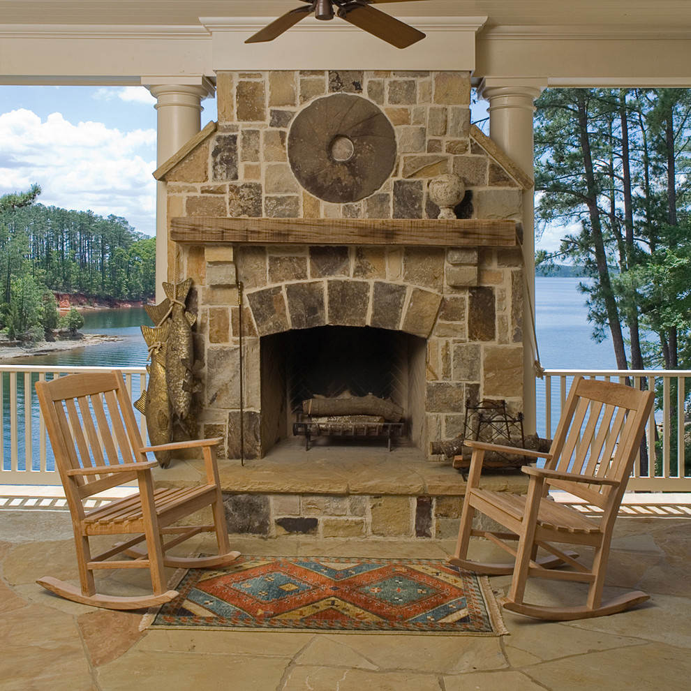 Cette photo montre un porche d'entrée de maison chic avec des pavés en pierre naturelle et un foyer extérieur.