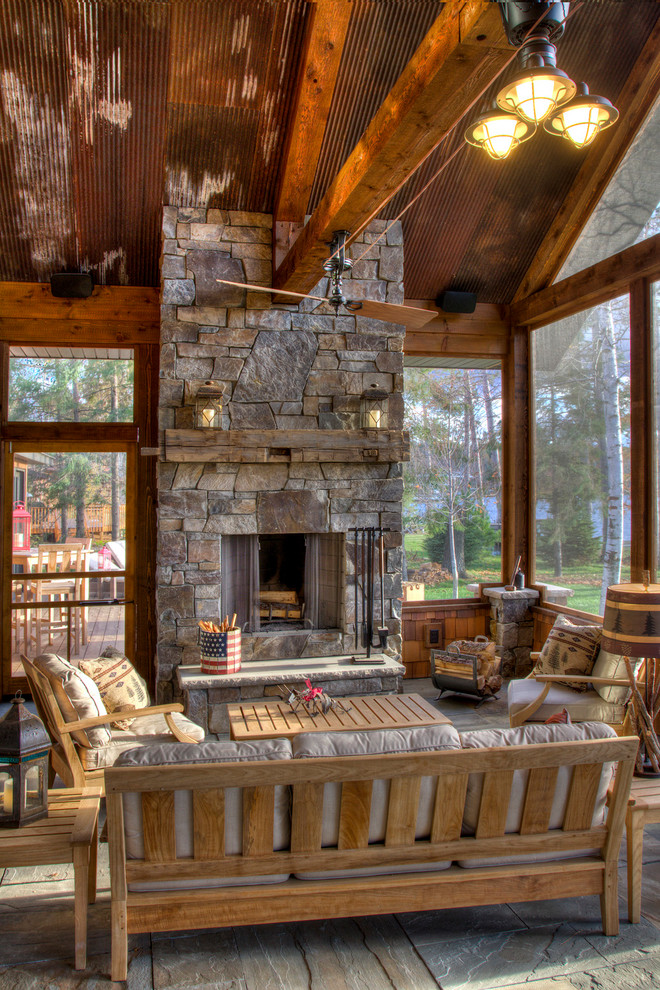 Idées déco pour un grand porche d'entrée de maison montagne avec des pavés en pierre naturelle, une extension de toiture et une moustiquaire.