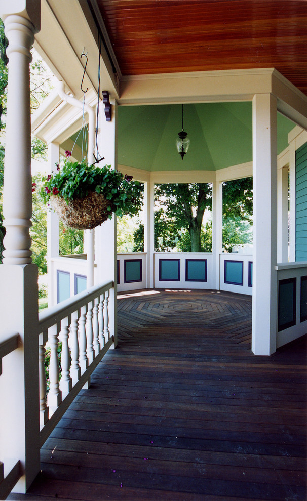 Foto på en stor vintage veranda framför huset, med trädäck