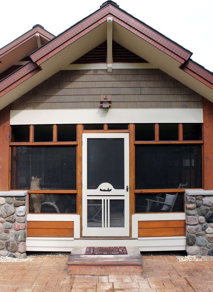 Réalisation d'un porche d'entrée de maison latéral chalet de taille moyenne avec une moustiquaire et une extension de toiture.