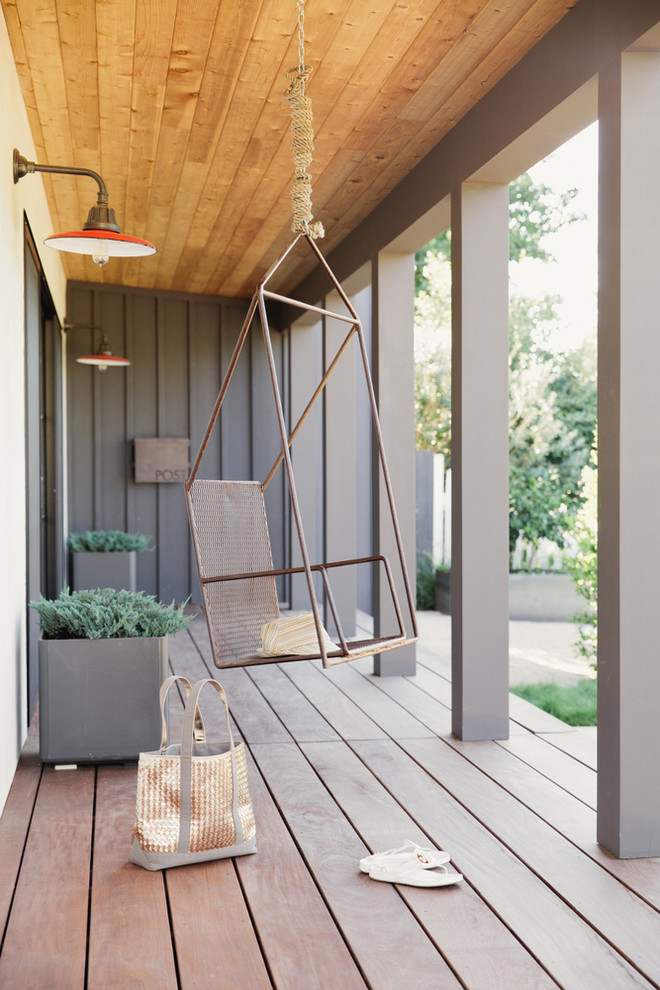 This is an example of a transitional porch design in San Francisco with decking and a roof extension.