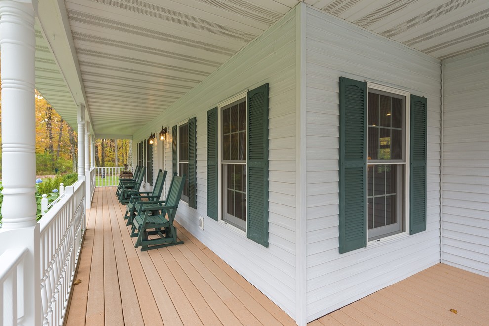 Idée de décoration pour un porche d'entrée de maison avant champêtre de taille moyenne avec une terrasse en bois et une extension de toiture.