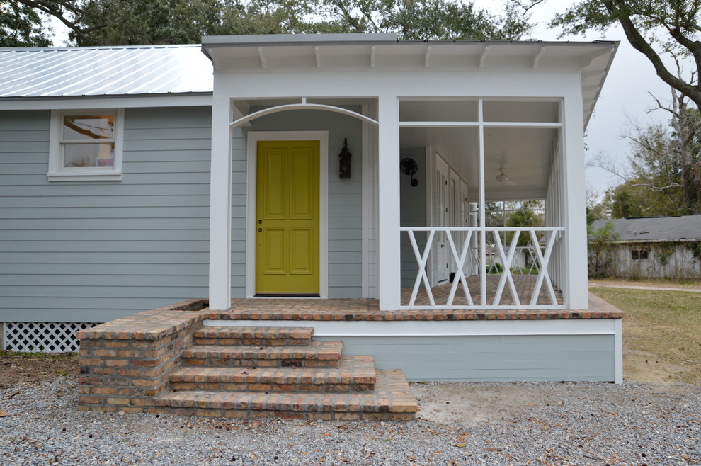 Réalisation d'un porche d'entrée de maison avant tradition avec des pavés en brique et une extension de toiture.