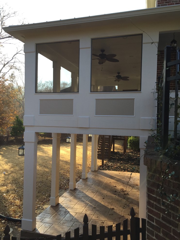 Idées déco pour un porche d'entrée de maison classique avec une moustiquaire et du béton estampé.