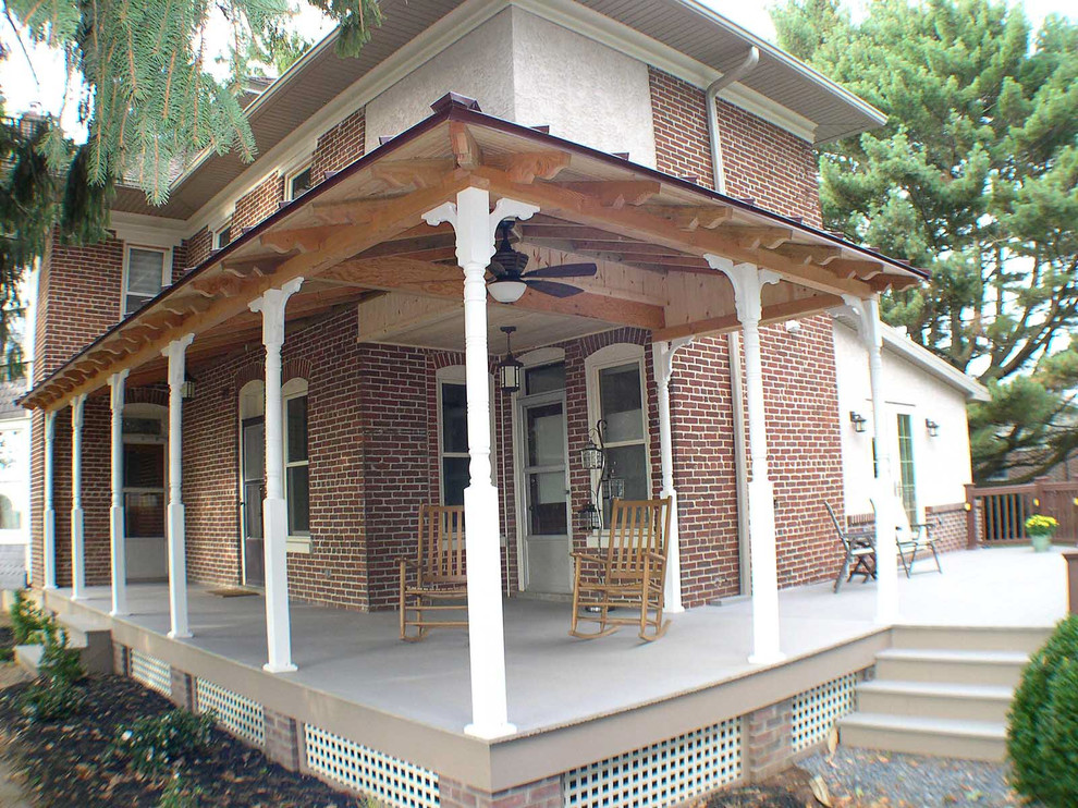 Foto di un portico classico di medie dimensioni e davanti casa con un tetto a sbalzo