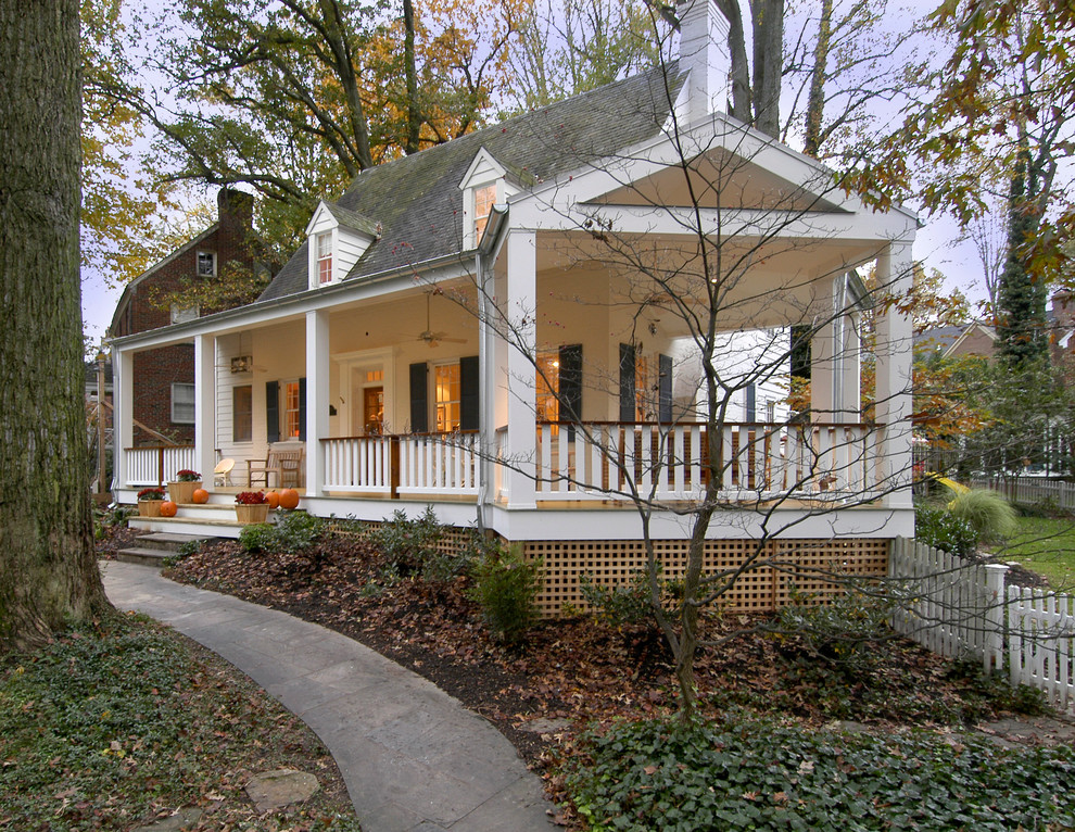 Elegant stone front porch photo in DC Metro with a roof extension
