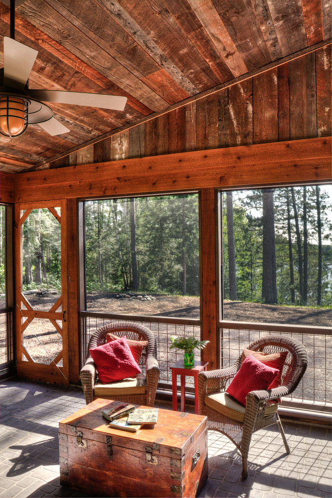 Exemple d'un porche d'entrée de maison latéral montagne de taille moyenne avec une moustiquaire, une extension de toiture et des pavés en béton.