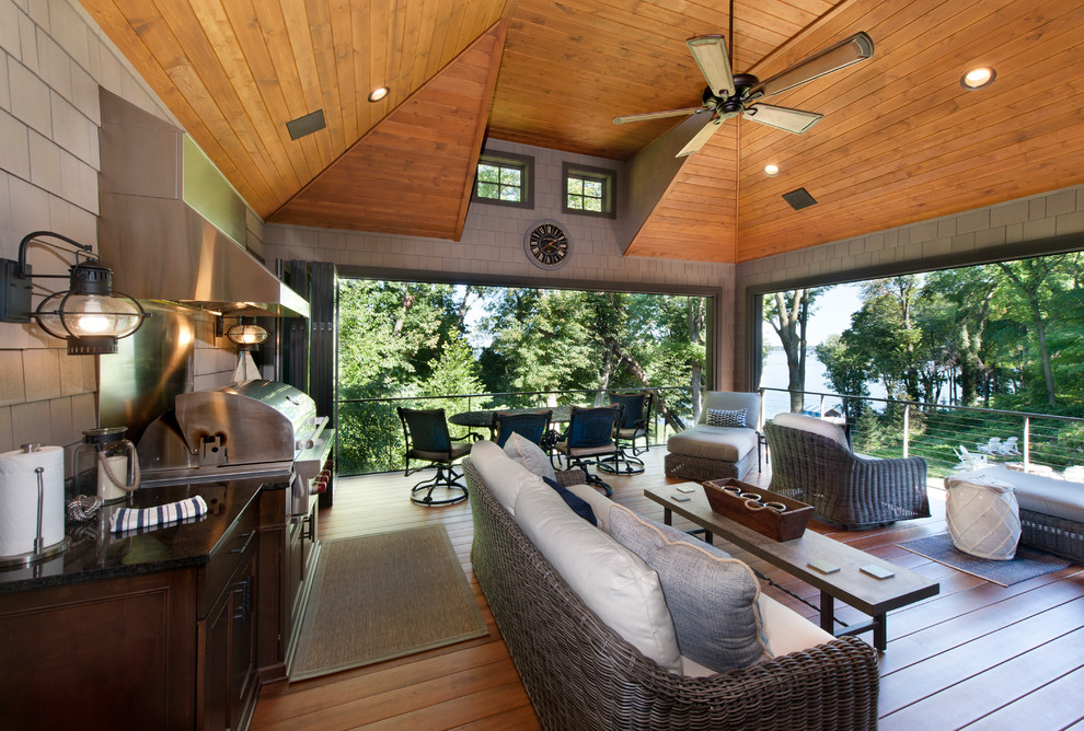 Aménagement d'un grand porche d'entrée de maison arrière bord de mer avec une moustiquaire, une terrasse en bois et une extension de toiture.