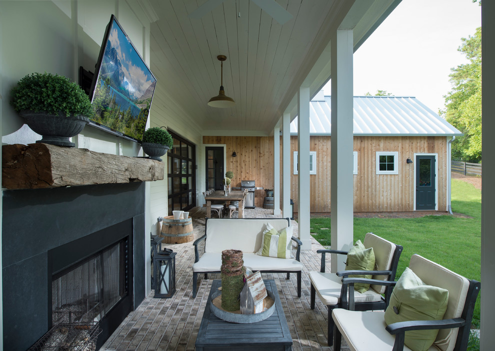 Foto de terraza de estilo de casa de campo grande en patio trasero y anexo de casas con brasero y adoquines de ladrillo