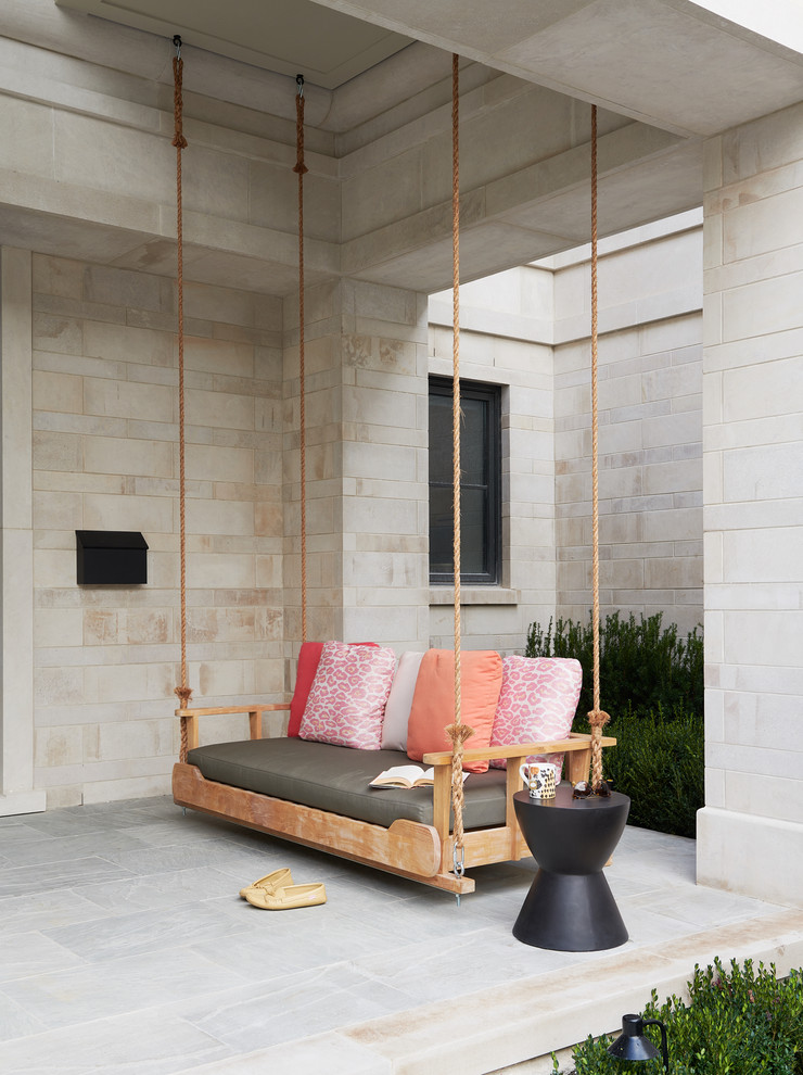 Inspiration pour un porche d'entrée de maison avant minimaliste avec des pavés en béton et une extension de toiture.