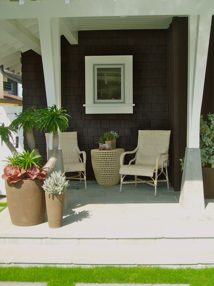 Cette photo montre un petit porche d'entrée de maison avant tendance avec du béton estampé et une extension de toiture.