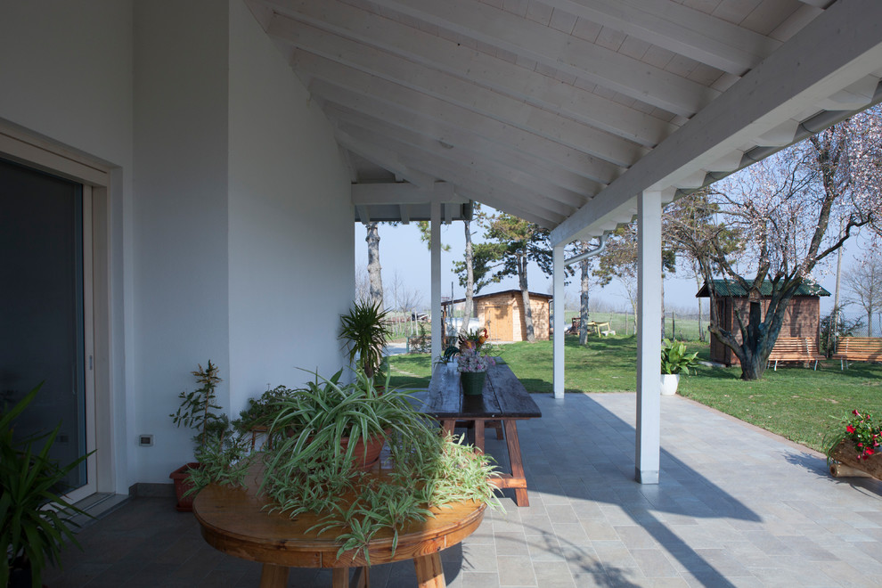 Idee per un portico country di medie dimensioni e nel cortile laterale con piastrelle e un tetto a sbalzo
