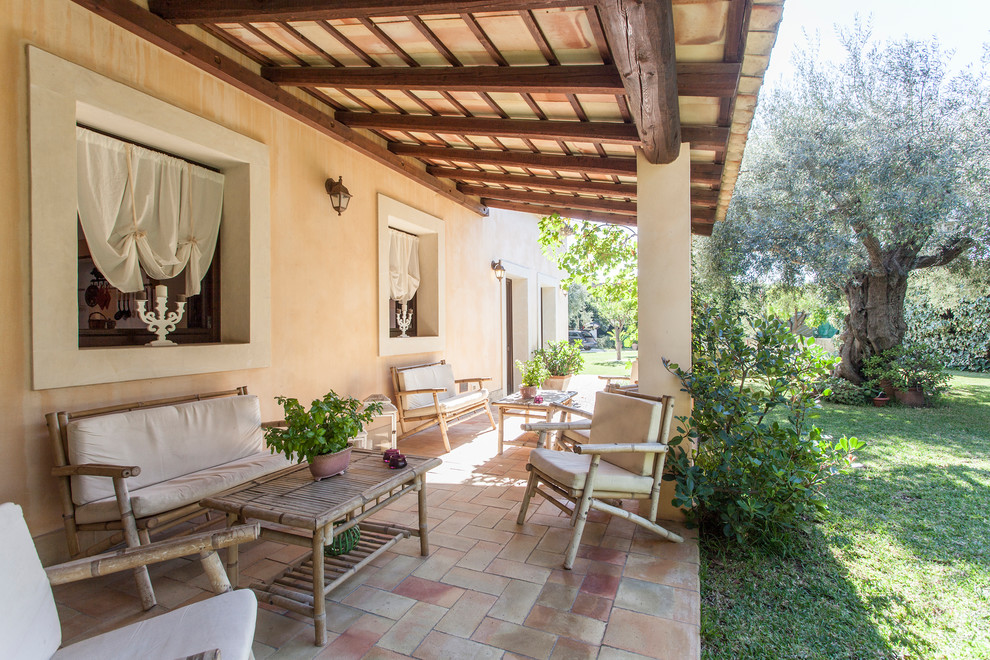 Idées déco pour un porche d'entrée de maison méditerranéen avec des pavés en brique et un auvent.
