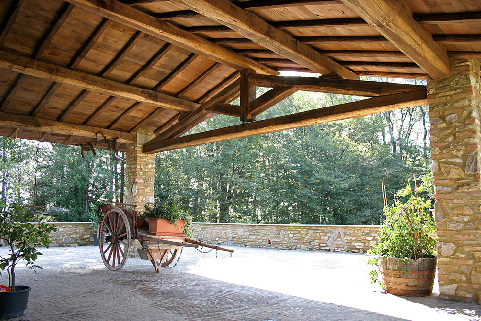 Aménagement d'un grand porche d'entrée de maison latéral campagne avec des pavés en pierre naturelle et une extension de toiture.