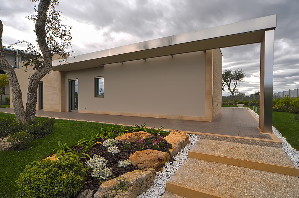 Idée de décoration pour un porche d'entrée de maison design avec une extension de toiture.