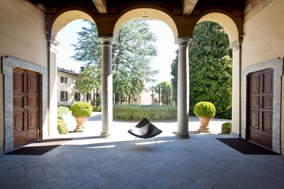 Immagine di un ampio portico mediterraneo nel cortile laterale con pavimentazioni in pietra naturale