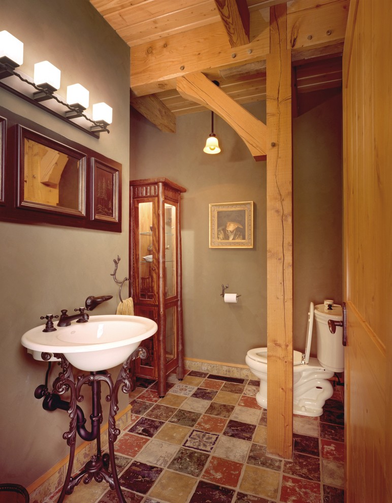 На фото: туалет среднего размера в стиле рустика с раковиной с пьедесталом, раздельным унитазом и зелеными стенами с