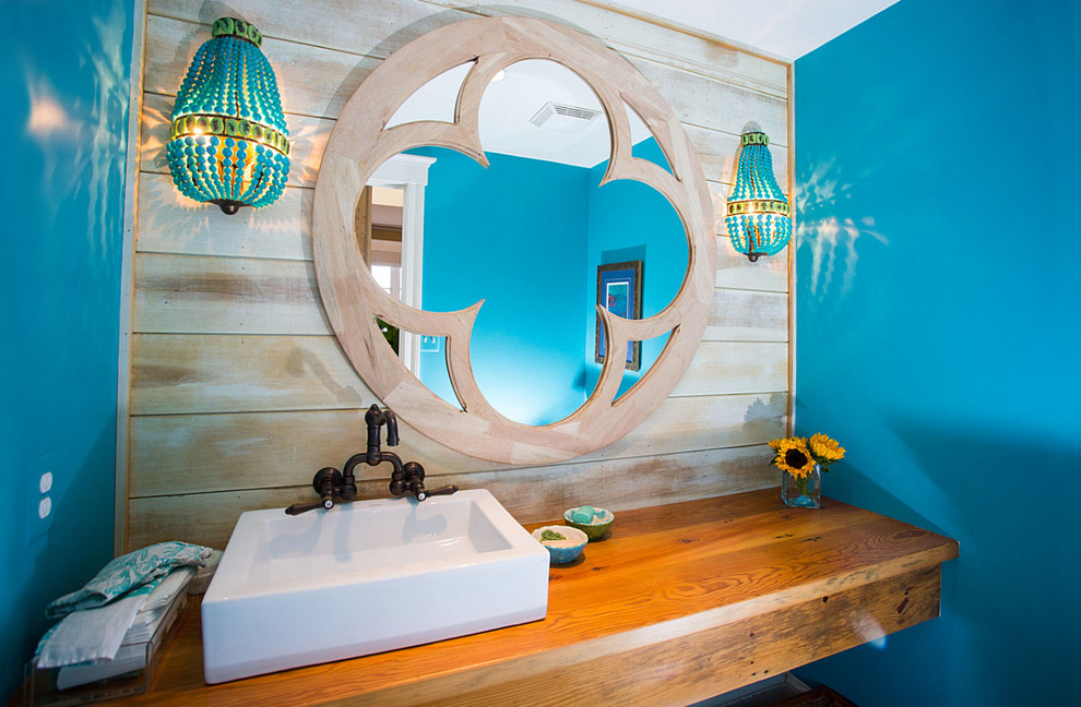 На фото: туалет среднего размера в морском стиле с настольной раковиной, столешницей из дерева, раздельным унитазом, коричневой плиткой, синими стенами и паркетным полом среднего тона с