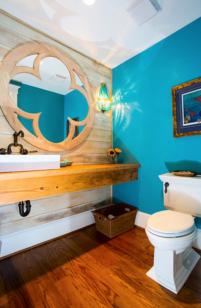 ボルチモアにある中くらいなビーチスタイルのおしゃれなトイレ・洗面所 (ベッセル式洗面器、木製洗面台、分離型トイレ、青い壁、無垢フローリング、ブラウンの洗面カウンター) の写真