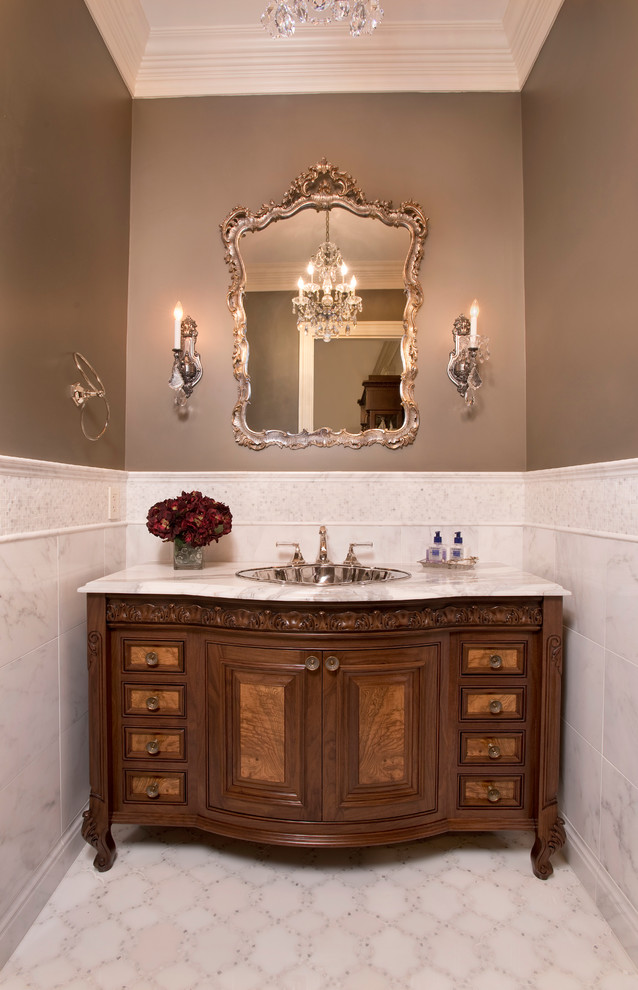 Powder room - mid-sized traditional white tile and stone tile marble floor powder room idea in Boston with raised-panel cabinets, dark wood cabinets, a two-piece toilet, gray walls, a drop-in sink and marble countertops