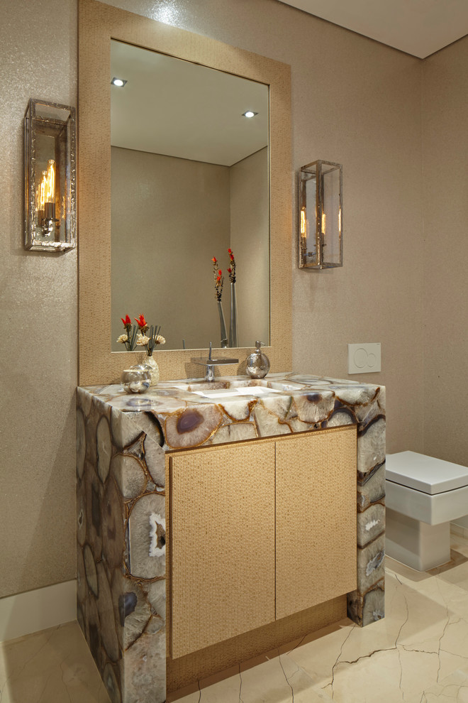 Cette photo montre un WC suspendu tendance avec un lavabo encastré, un mur beige, un placard à porte plane et des portes de placard beiges.