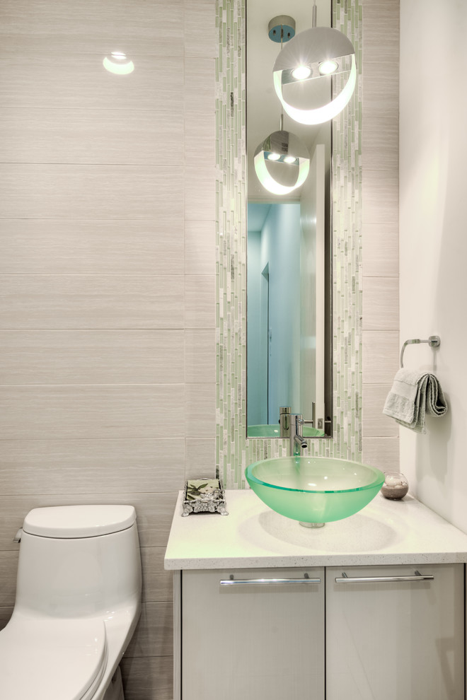 Immagine di un bagno di servizio minimalista di medie dimensioni con ante lisce, ante grigie, pareti grigie, lavabo a bacinella e top in superficie solida