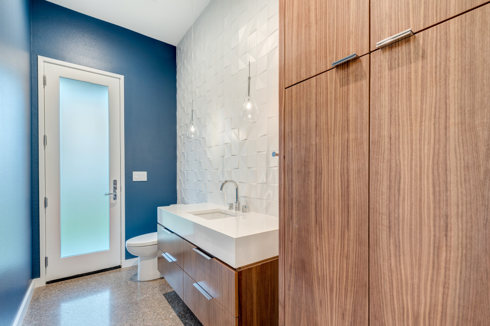 Cette image montre un WC et toilettes minimaliste en bois brun de taille moyenne avec un placard à porte plane, WC séparés, un carrelage blanc, des carreaux de porcelaine, un mur bleu, sol en béton ciré, un lavabo encastré, un plan de toilette en quartz modifié, un sol gris, un plan de toilette blanc et meuble-lavabo sur pied.