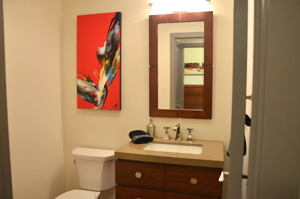 Idee per un piccolo bagno di servizio moderno con lavabo sottopiano, ante lisce, ante in legno bruno, top in superficie solida, WC a due pezzi, piastrelle bianche e pareti bianche