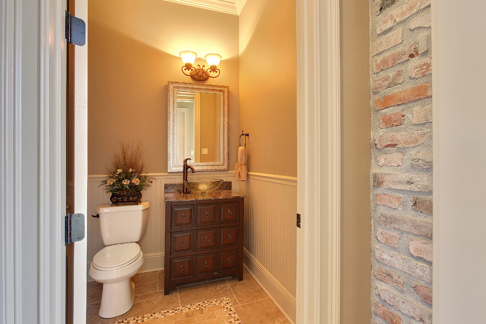 Example of a classic beige tile powder room design in New Orleans with a vessel sink, furniture-like cabinets, dark wood cabinets, granite countertops and beige walls