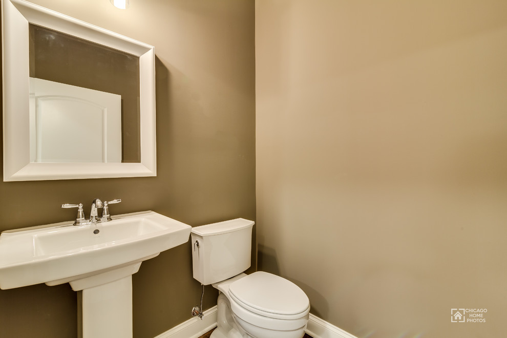Mittelgroße Klassische Gästetoilette mit brauner Wandfarbe, braunem Holzboden und Sockelwaschbecken in Chicago